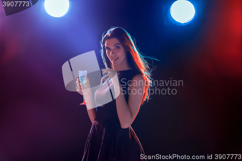 Image of The beautiful girl dancing at the party drinking champagne