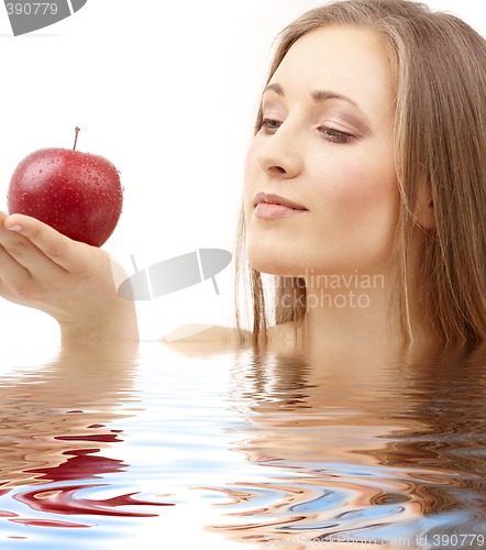 Image of woman with red apple in water