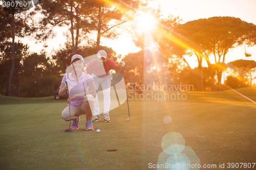 Image of couple on golf course at sunset