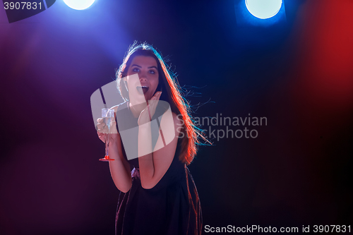 Image of The beautiful girl dancing at the party drinking champagne