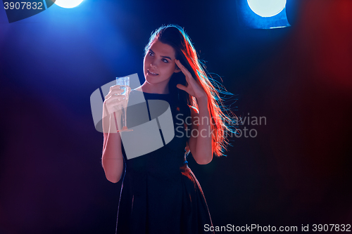 Image of The beautiful girl dancing at the party drinking champagne