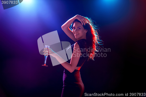 Image of The beautiful girl dancing at the party drinking champagne