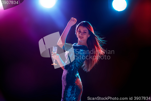 Image of The beautiful girl dancing at the party drinking champagne
