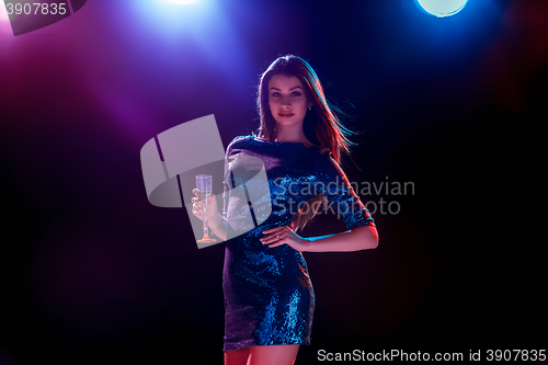 Image of The beautiful girl dancing at the party drinking champagne