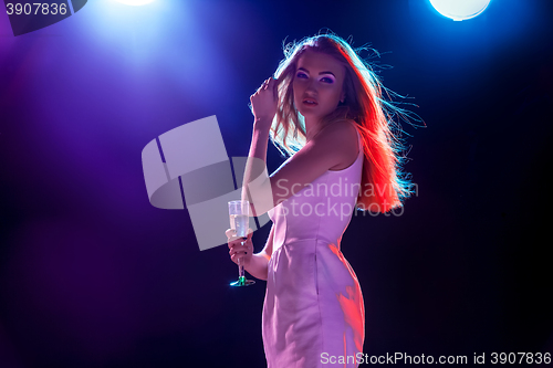 Image of The beautiful girl dancing at the party drinking champagne