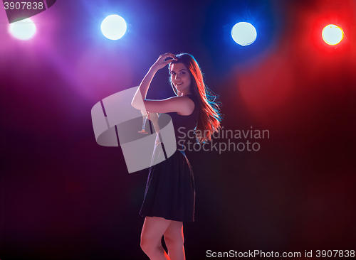 Image of The beautiful girl dancing at the party drinking champagne