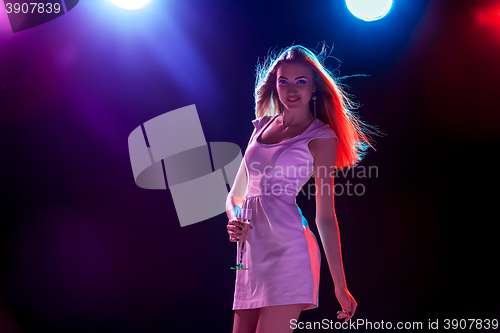 Image of The beautiful girl dancing at the party drinking champagne