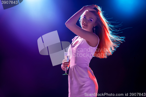 Image of The beautiful girl dancing at the party drinking champagne
