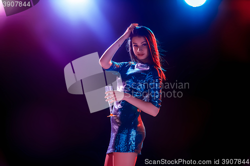 Image of The beautiful girl dancing at the party drinking champagne