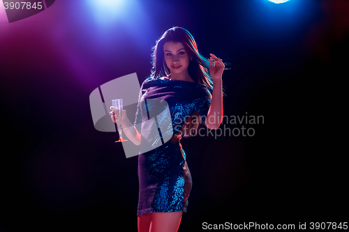 Image of The beautiful girl dancing at the party drinking champagne