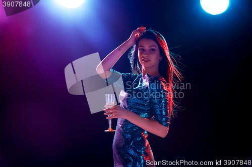 Image of The beautiful girl dancing at the party drinking champagne
