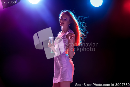 Image of The beautiful girl dancing at the party drinking champagne