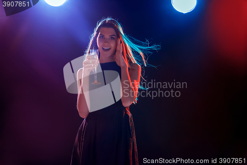 Image of The beautiful girl dancing at the party drinking champagne