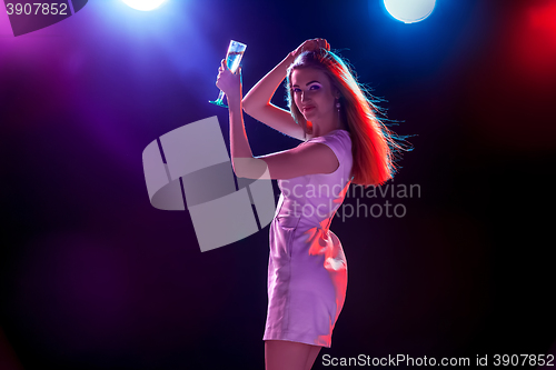 Image of The beautiful girl dancing at the party drinking champagne
