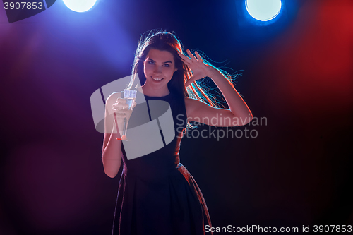 Image of The beautiful girl dancing at the party drinking champagne