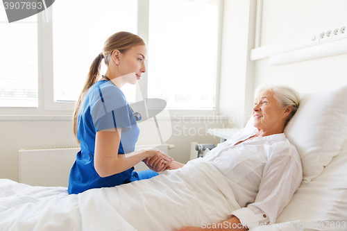 Image of doctor or nurse visiting senior woman at hospital