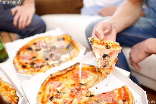 Image of close up of friends with beer and pizza at home