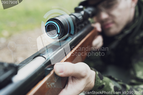 Image of close up of soldier or sniper with gun in forest