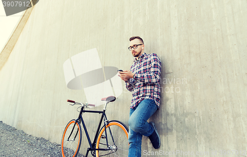 Image of hipster man in earphones with smartphone and bike