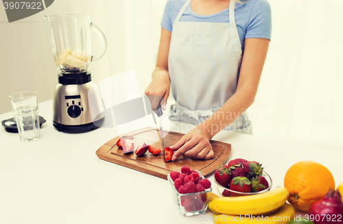 Image of close up of woman chopping strawberry at home