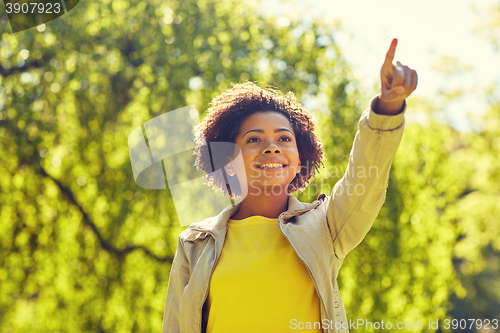Image of happy african american young woman in summer park