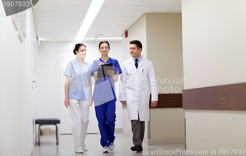 Image of group of smiling medics at hospital with clipboard