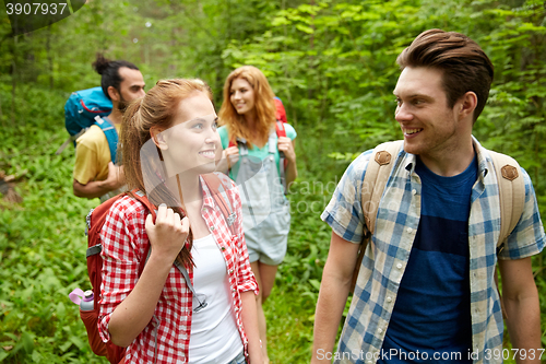 Image of group of smiling friends with backpacks hiking