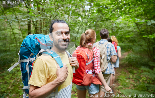 Image of group of smiling friends with backpacks hiking