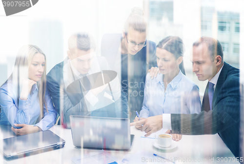 Image of business team with laptop having discussion