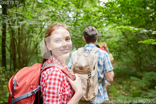 Image of group of smiling friends with backpacks hiking