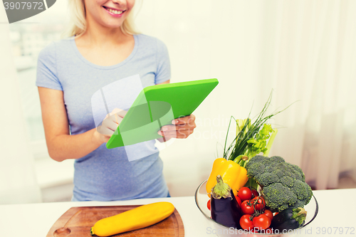 Image of close up of woman with tablet pc cooking at home