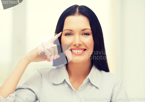 Image of smiling woman pointing to imaginy glasses