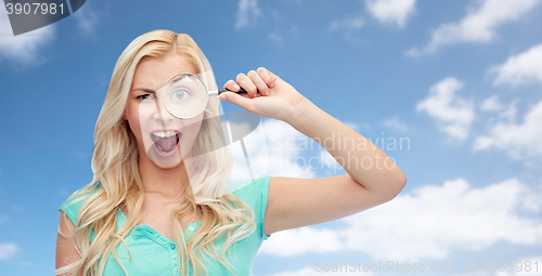 Image of happy young woman with magnifying glass