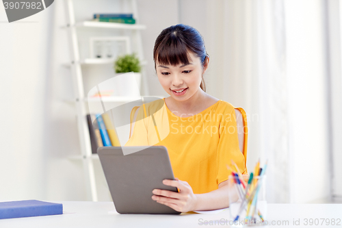 Image of happy asian woman student with tablet pc at home