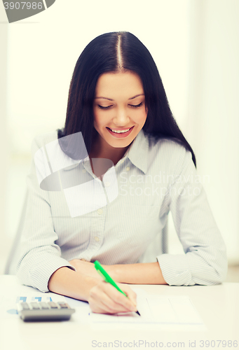 Image of businesswoman or student working with calculator