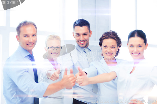 Image of business team showing thumbs up in office