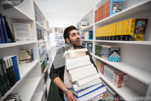 Image of Student holding lot of books in school library