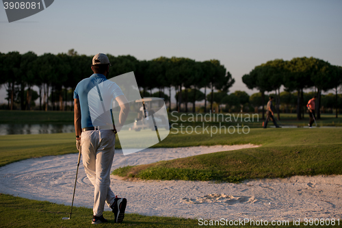 Image of golfer from back at course looking to hole in distance