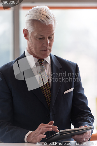 Image of senior business man working on tablet computer