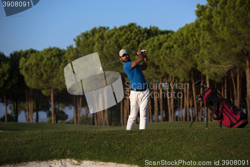 Image of golfer hitting a sand bunker shot on sunset