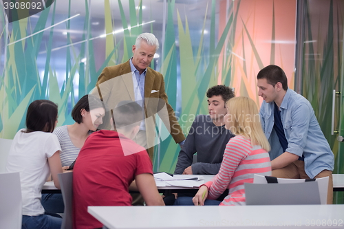 Image of teacher with a group of students in classroom