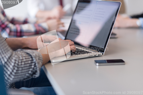 Image of close up of business man hands typing on laptop with team on mee