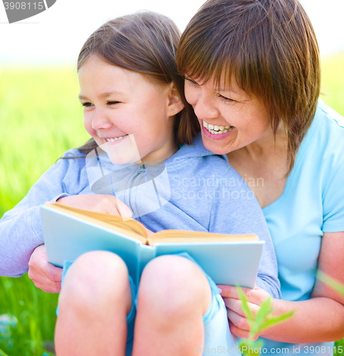 Image of Mother is reading book with her daughter