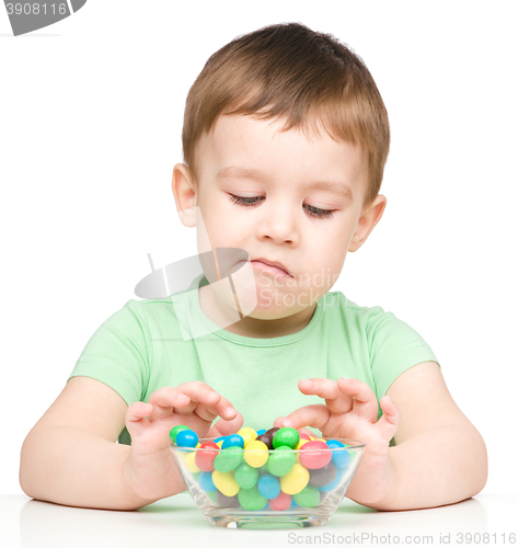 Image of Portrait of a sad little boy with candies