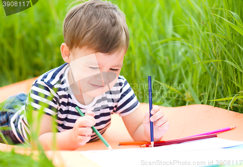 Image of Little boy is playing with pencils