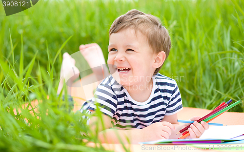 Image of Little boy is playing with pencils