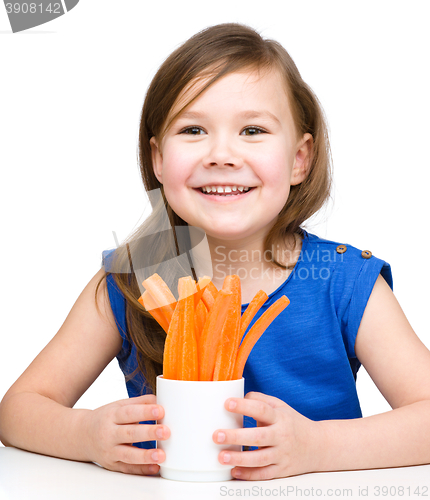Image of Cute little girl is eating carrot