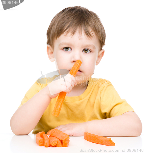 Image of Little boy is eating carrot