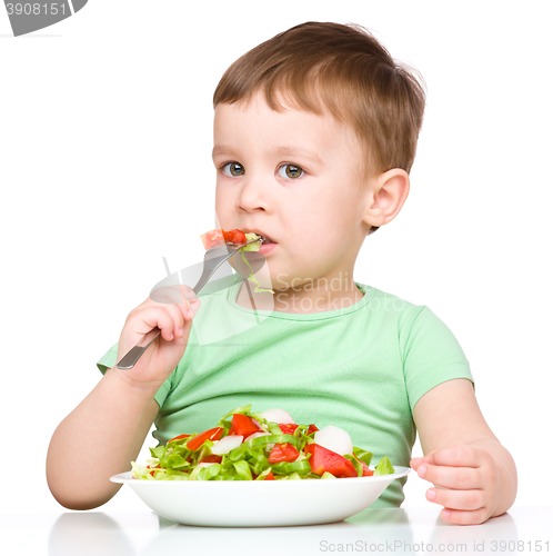 Image of Cute little boy is eating vegetable salad