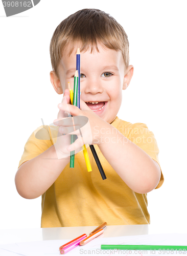 Image of Little boy is playing with color pencils